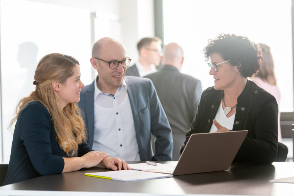Das Foto zeigt drei Mitarbeitende der SaarLB bei einer Besprechung