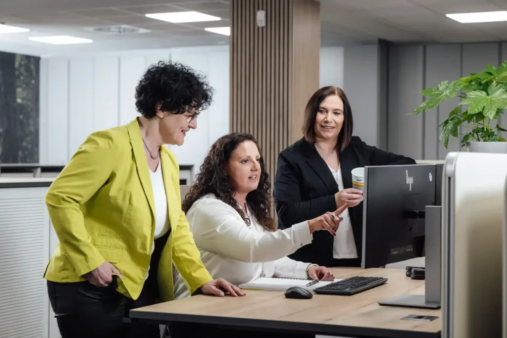 Das Foto zeigt drei Mitarbeitende des Teams Business Payments